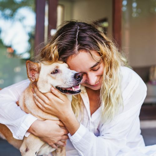 lady hugging a dog after reiki session