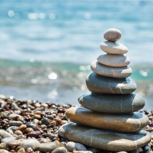 successful stress relief performed through the use of reiki, using stone balancing on a beach as representation